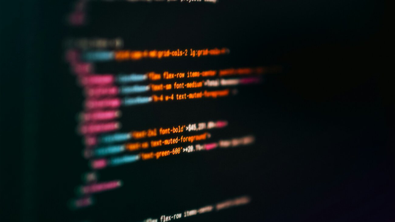 Computer screen with colourful code, representing the build vs buy decision for custom software