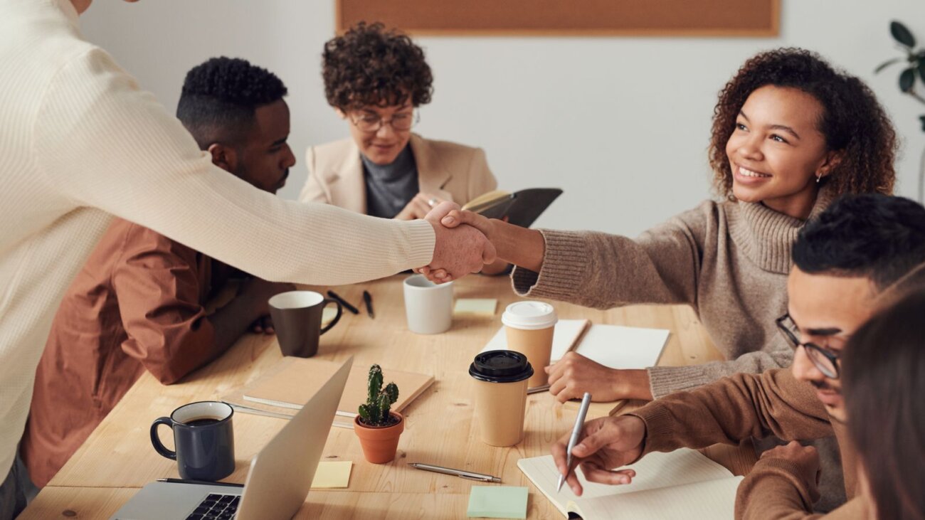 Colleagues shaking hands in an office meeting, sealing a partnership
