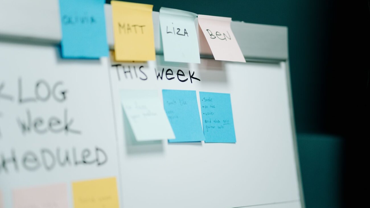 Whiteboard covered in colourful sticky notes for project planning